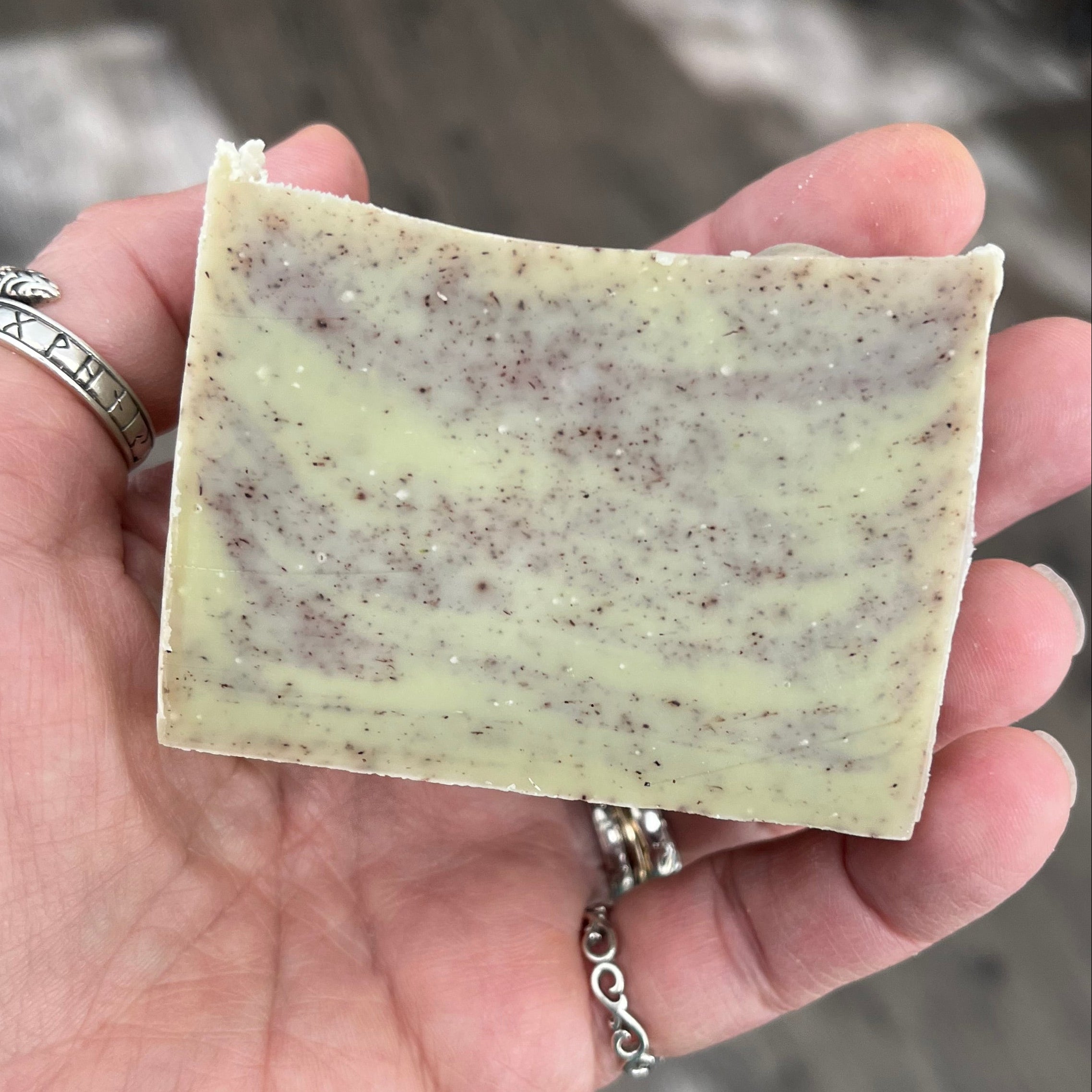 Hand holding a bar of soap with a blurred background
