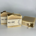 Three bars of Milk + Honey handcrafted soap on a simple gray background.