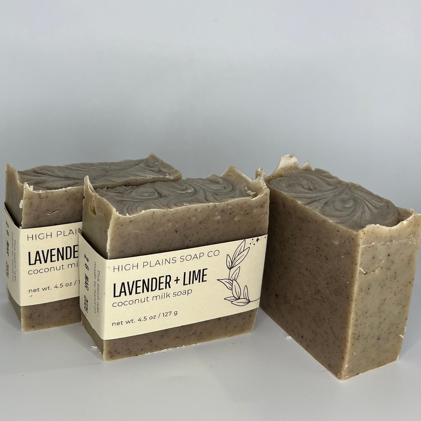 Three bars of soap with packaging on a light gray background